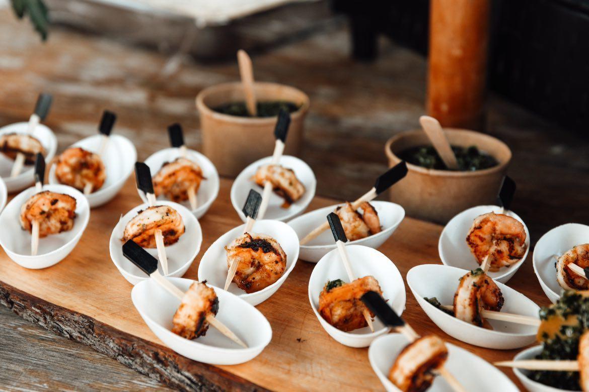 Bouchées de crevettes grillées dressées sur cuillères blanches