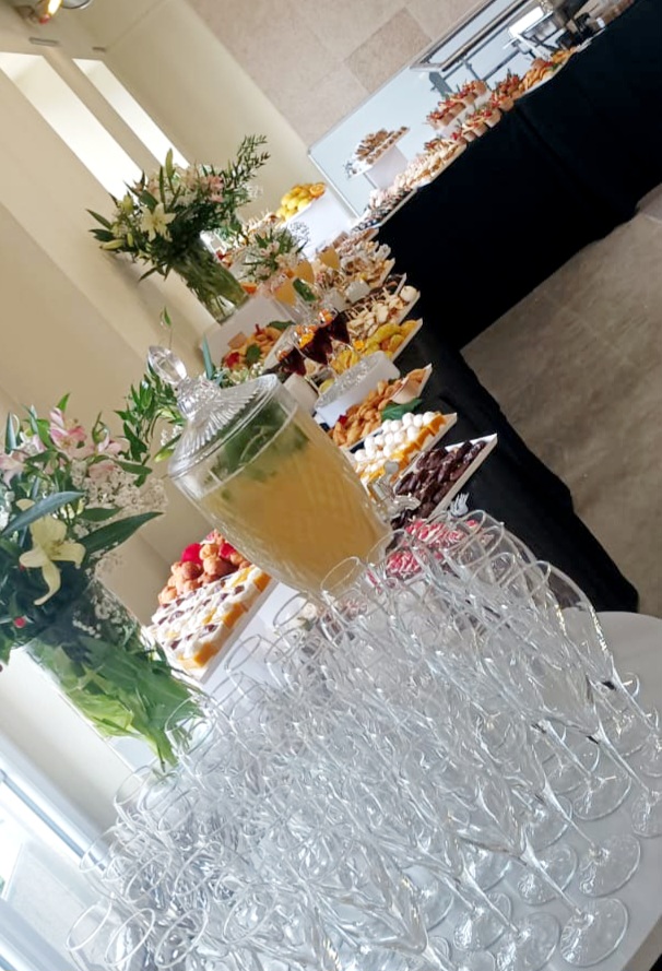 Buffet de réception fleuri avec boissons et douceurs