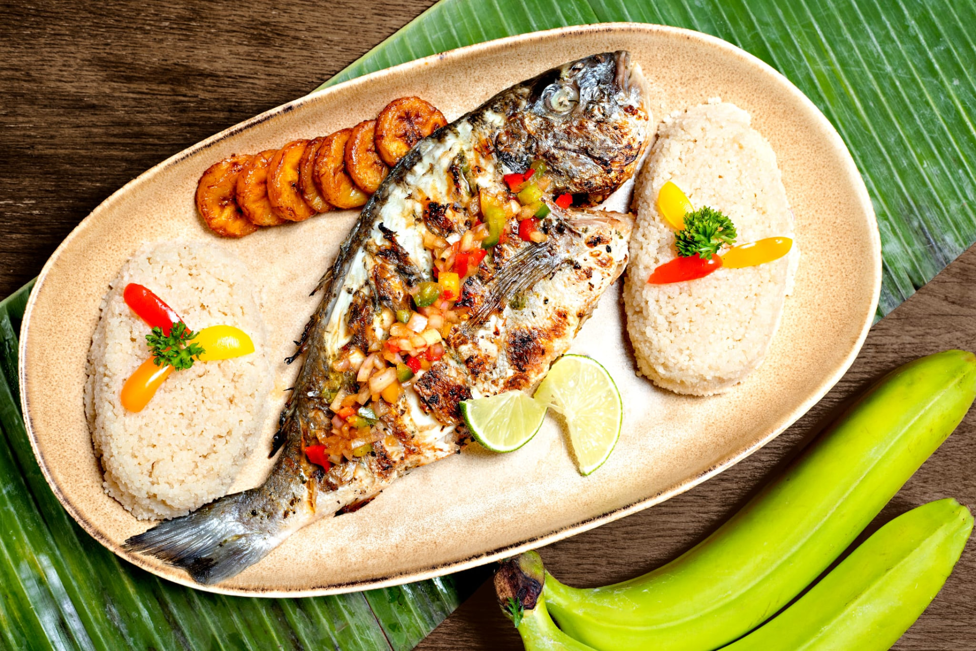 Poisson braisé servi avec attiéké et plantains frits