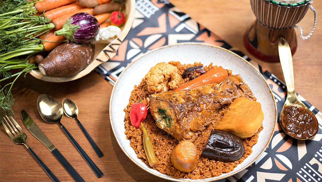 Thiébou dieune à l’agneau servi avec ses légumes sur une nappe africaine